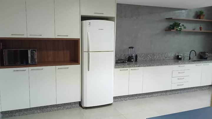 Cozinha completa com armários brancos e geladeira