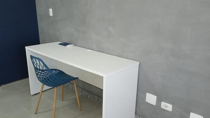 Mesa de trabalho branca com cadeira azul