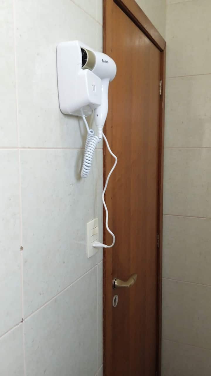 Secador de cabelo fixado na parede do banheiro