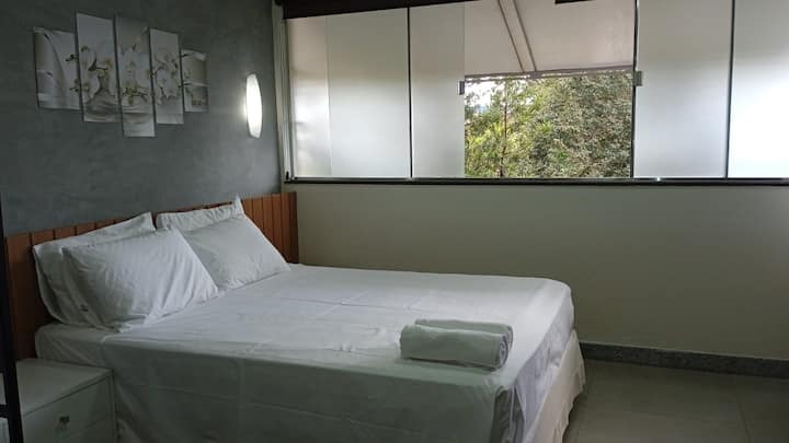 Vista do quarto com janela ampla e iluminação natural